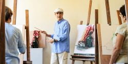 Artist instructor with paintings