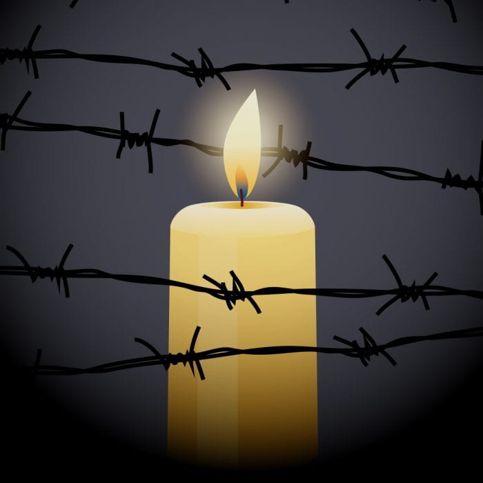 Candle behind barbed wire